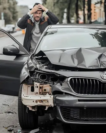 A car with front end collision damage before repair.